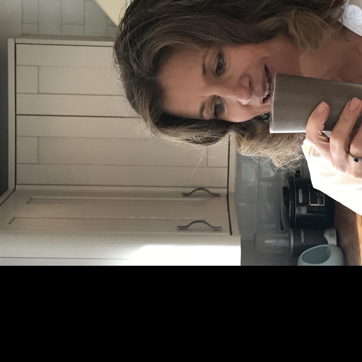 Liz, smiling, in her kitchen